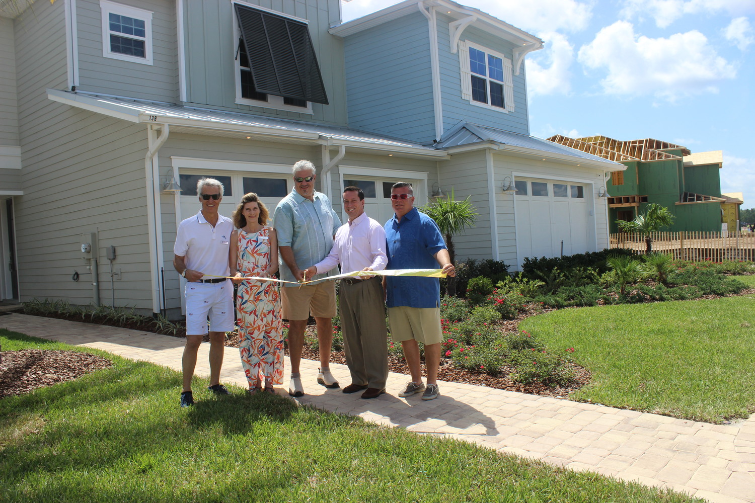 St. Johns County Commissioner Jimmy Johns (second from right) gathers with leadership from Americrest Luxury Homes for a ribbon-cutting ceremony at the grand opening event for Atlantica Isles at Beachwalk on June 23.